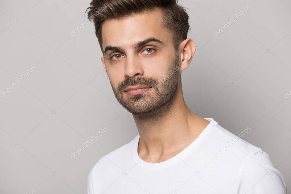 Close up of serious caucasian man posing on grey background