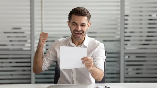 Счастливый бизнесмен, читающий документ, деловое письмо, взволнованный хорошей новостью — стоковое фото