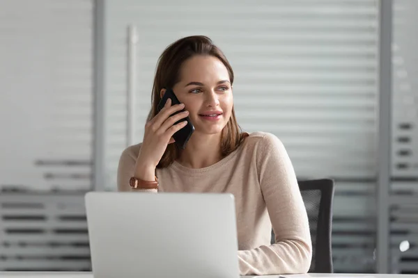 Femme d'affaires souriante parlant au téléphone, utilisant un ordinateur portable, passant un appel d'affaires — Photo