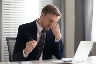 İş adamı gözlüğünü çıkarıyor, kuru göz sendromundan muzdarip.