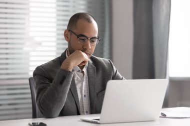 Düşünceli Afro-Amerikan iş adamı dizüstü bilgisayar kullanıyor, düşünceli proje