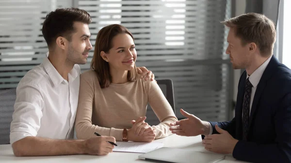 Selbstbewusster Manager berät junges Paar bei Treffen über Vertrag — Stockfoto