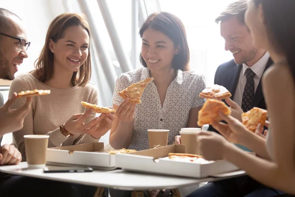 Felices empleados diversos disfrutando de la pizza, divirtiéndose durante el descanso juntos — Foto de Stock