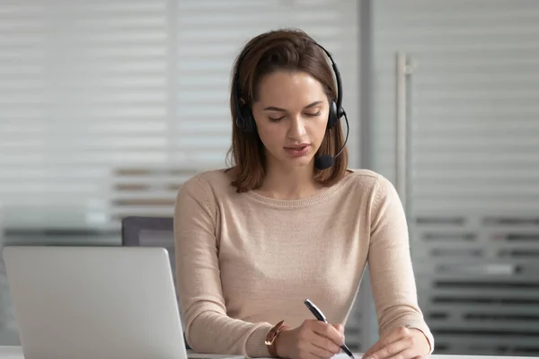 Busy businesswoman in headset consulting client or learning online — Stock Photo, Image