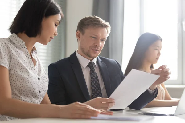 Asian businesswoman discussing legal documents with Caucasian businessman — Stock Photo, Image