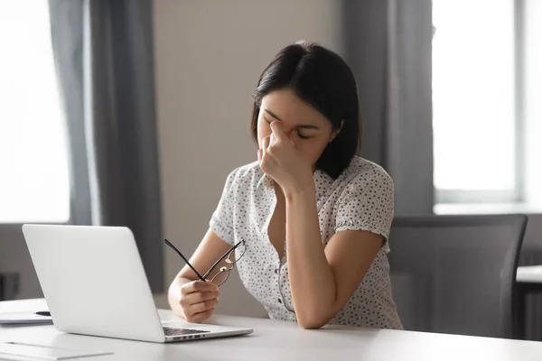 Fatigué asiatique femme d'affaires décoller des lunettes, massage nez pont — Photo