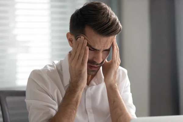 Unhappy businessman massaging temples, suffering from strong headache — Stock Photo, Image