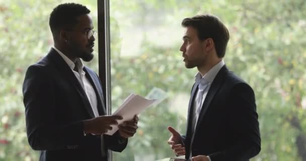 Dos diversos socios masculinos diseñadores hablando apretón de manos de pie en la oficina — Vídeos de Stock