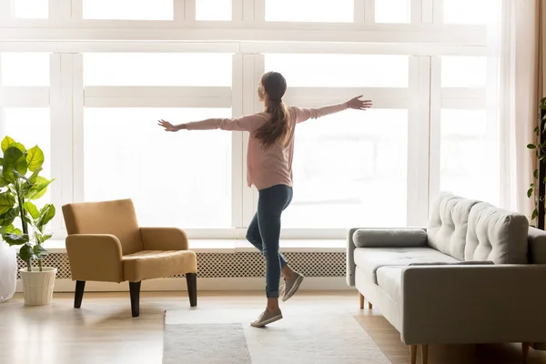 Glücklich aktive junge Frau tanzt allein im modernen Wohnzimmer — Stockfoto