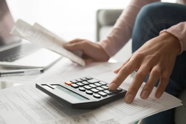 Mujer usando calculadora sosteniendo gastos de planificación de facturas, vista de cerca — Foto de Stock