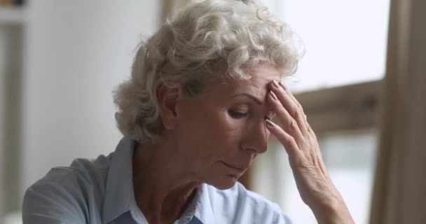 Üzgün, düşünceli, yaşlı bir kadın. Evdeki sağlık sorunları için endişeleniyor. — Stok video