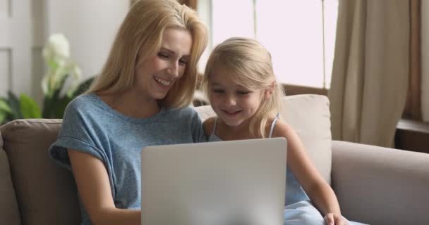 Gelukkig mam en schattig kind dochter hebben plezier met behulp van laptop — Stockvideo