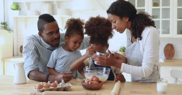 Fofa pequena filha africana ajudando a família preparando massa na cozinha — Vídeo de Stock