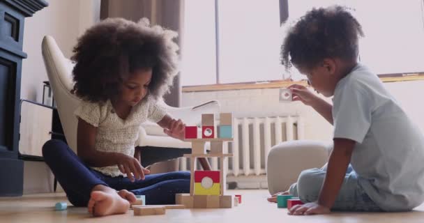 African children playing with wooden blocks on warm heated floor — Stock Video