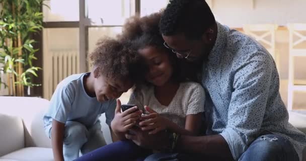 Happy african dad and little kids laughing using mobile apps — Stock Video
