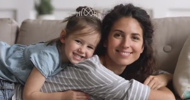 Feliz madre e hija mirando a la cámara en el sofá — Vídeo de stock