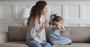 Kızgın anne azarlıyor inatçı çocuk kız kulaklarını kapatıyor dinlemiyor