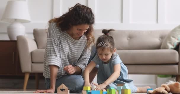 Милая маленькая девочка и мама смеются играть деревянные блоки — стоковое видео
