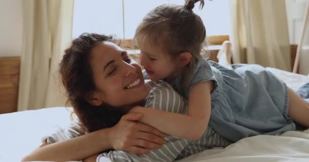 Mignon petit enfant fille embrasser baiser maman couchée sur le lit — Video