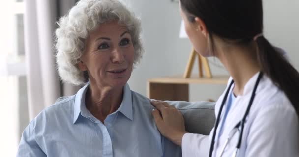 Paciente idoso feliz e enfermeira conversando durante consulta médica — Vídeo de Stock