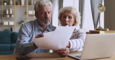 Hesapları kontrol eden yaşlı çift ödenmemiş borç vergilerini tartışıyor.