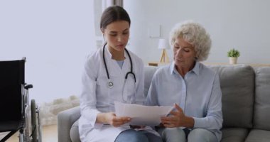 Genç doktor, engelli yaşlı büyükannene tıbbi test sonuçları göster.