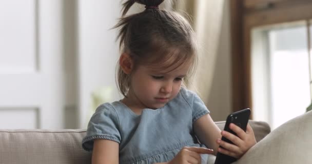 Schattig slim kind meisje houden met behulp van smartphone alleen thuis — Stockvideo