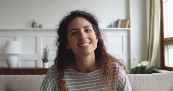 Веселая молодая женщина, разговаривающая с камерой дома — стоковое видео
