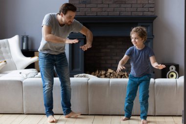 Mutlu baba modern oturma odasında oğluyla dans ediyor.