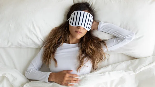 Ruhige friedliche gemischte Rasse junge Frau trägt Schlafmaske, träumt. — Stockfoto