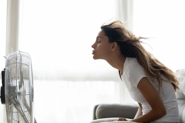 Young mixed race woman sitting in front of ventilator. — Stock Photo, Image