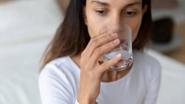 Joven mujer de raza mixta bebiendo vaso de agua dulce pura . — Foto de Stock