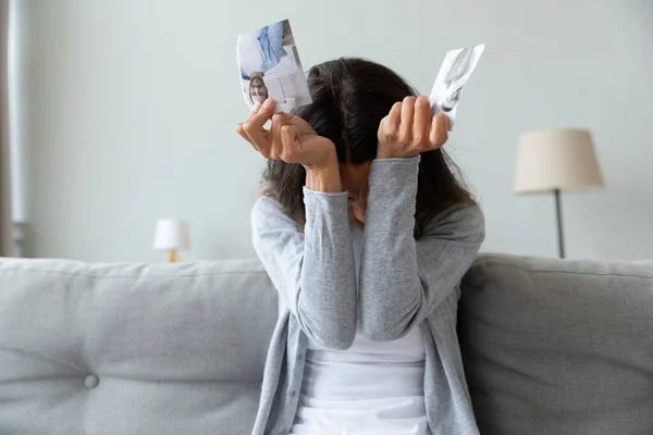 Frustrierte junge Mischlingshündin mit zerrissenem Foto von Paar. — Stockfoto