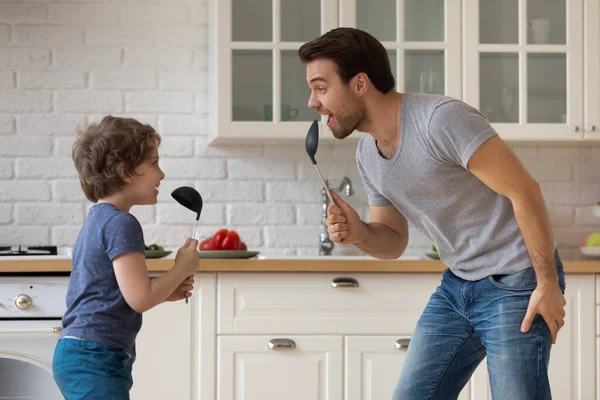 Heureux père et petit fils jouant, s'amusant dans la cuisine — Photo