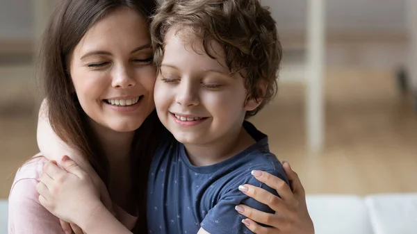 Улыбающиеся мать и маленький сын трогают щеки, наслаждаясь нежным моментом — стоковое фото