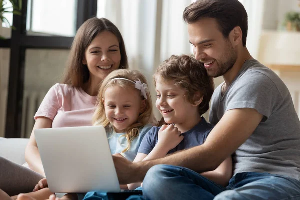 Parents heureux avec petite fille et fils utilisant un ordinateur portable — Photo