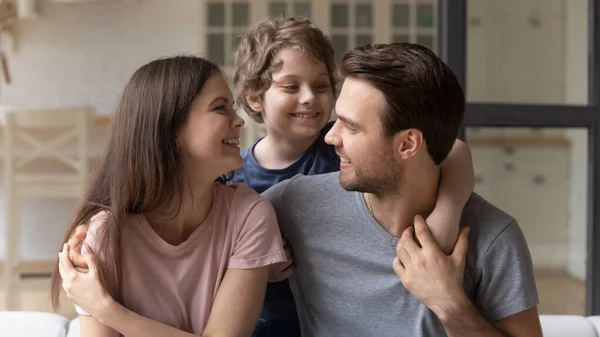 Kleiner Sohn umarmt glückliche Mutter und Vater und genießt zärtlichen Moment — Stockfoto