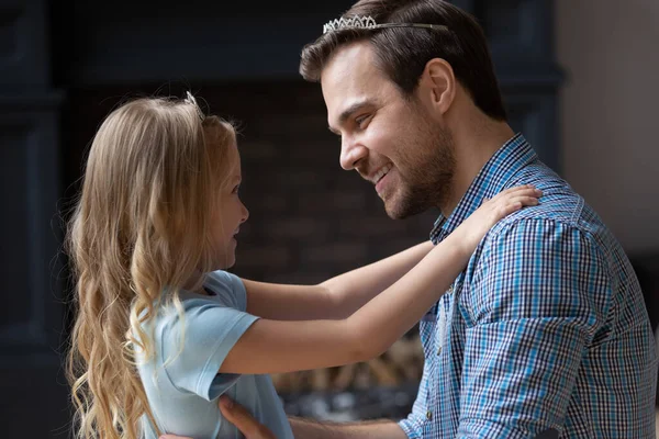 Sorridente padre e figlia con le corone che si abbracciano a casa — Foto Stock