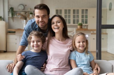 Küçük kız ve oğluyla mutlu bir aile portresi.