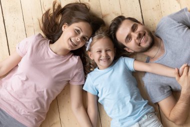 Mutlu anne, baba ve küçük kız el ele tutuşuyorlar.