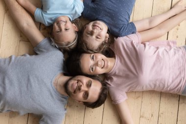 Mutlu ebeveynler ve küçük çocuklar yerde yatıyorlar.