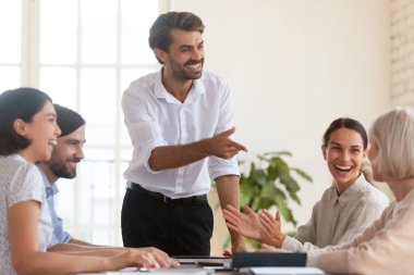 Mutlu iş ekibi, grup toplantısındaki yaşlı bayan yöneticiyi takdir ediyor.