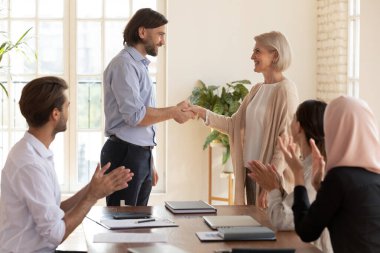Mutlu orta yaşlı bayan çalışan terfi takımı takdirini kazandı.