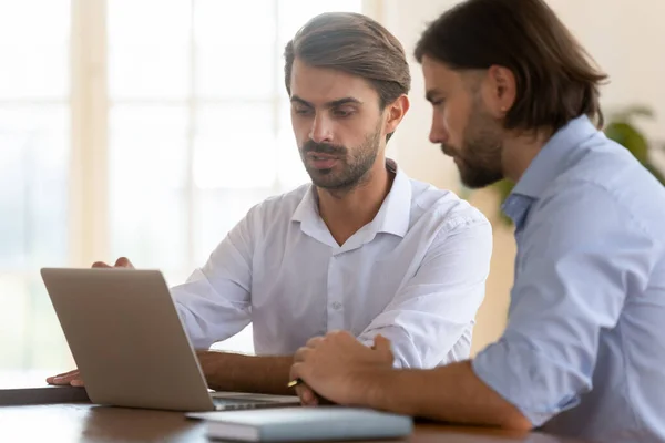 Focused businessman salesman consult male client show presentation on laptop — Stock Photo, Image