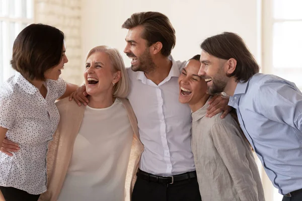 Cheerful multiethnic business team people laughing bonding standing in office