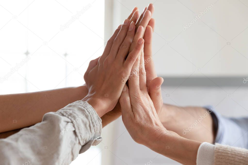 Corporate business team hands joined together, close up view