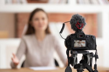 Kameranın önünde oturan kadın eğitici video çekiyor