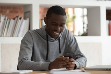 African man holds smartphone looks at screen read media news