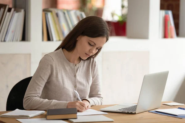 Kvinna som studerar sittande vid biblioteksbordet förbereder sig för inträdesprov — Stockfoto