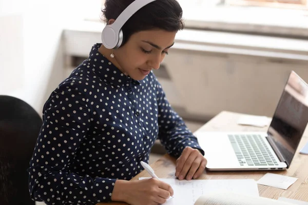 Indian ethnicity woman wearing headphones listens educational course studying online — Stock Photo, Image